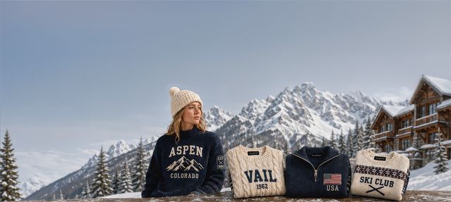 A model in an Aspen Colorado sweater beside folded Vail, USA and Ski Club knits on a snowy lodge rail